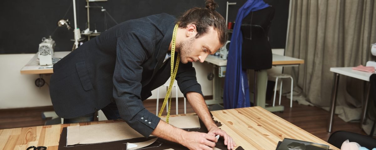 Un créateur d'uniformes professionnels en train de coudre